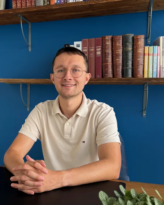 Timothée Guinchard à son bureau, devant sa bibliothèque.